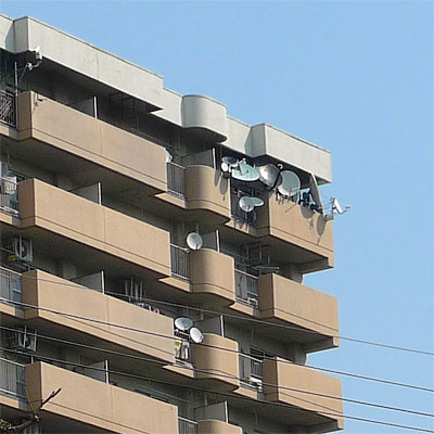 Many satellite dishes on an apartment balcony in Japan