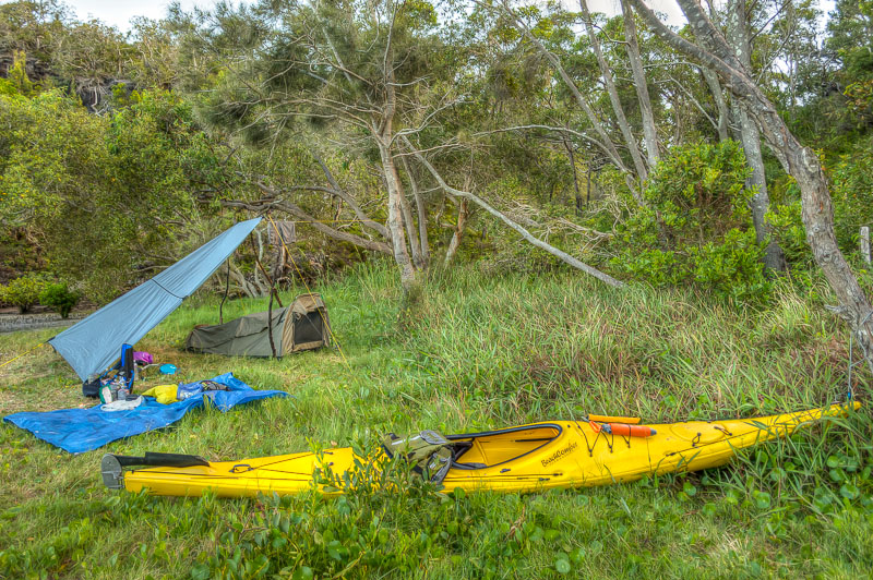 Kayak secured to a tree, shelter and swag setup